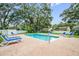 Community pool with plenty of lounge chairs and a brick-paved patio at 1486 Loman Ct, Palm Harbor, FL 34683