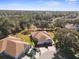 Aerial view of the house featuring a brick driveway, a two-car garage, and mature trees providing shade at 15038 Sterling Run, Brooksville, FL 34609