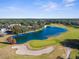 Scenic aerial view of the golf course featuring a lake and a sand trap with lush greenery and scattered trees around homes at 15038 Sterling Run, Brooksville, FL 34609