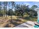 Expansive backyard with mature trees, lush greenery, and a brick patio perfect for outdoor relaxation and entertaining at 15038 Sterling Run, Brooksville, FL 34609