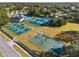 Aerial view of community with tennis courts, basketball court, clubhouse, and pool surrounded by well-maintained landscaping at 15038 Sterling Run, Brooksville, FL 34609