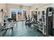 Well-equipped gym with modern equipment and plenty of natural light entering through glass doors and reflected from large mirror at 15038 Sterling Run, Brooksville, FL 34609