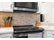 Close-up of a modern kitchen featuring stainless steel appliances and a stylish backsplash at 15038 Sterling Run, Brooksville, FL 34609