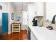 Bright eat-in kitchen with white cabinets, hardwood floors, stainless appliances, and a blue pantry door at 15038 Sterling Run, Brooksville, FL 34609