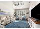 Comfortable living room featuring a soft couch, cozy armchairs, a blue rug, and a large window at 15038 Sterling Run, Brooksville, FL 34609