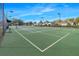 Brightly lit tennis court with surrounding neighborhood homes and clear blue skies at 15038 Sterling Run, Brooksville, FL 34609