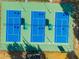 Aerial shot of three blue tennis courts, showing their layout with green borders and court markings at 15038 Sterling Run, Brooksville, FL 34609