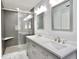 Stylish bathroom featuring a double vanity with modern fixtures and a glass-enclosed shower with gray tile at 1723 Cortleigh Dr, Trinity, FL 34655