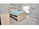 Bedroom showcasing a bed with light wood frame, plush carpeting, and natural light from a window at 1723 Cortleigh Dr, Trinity, FL 34655