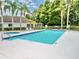 A community pool is surrounded by lush landscaping, palm trees, and comfortable lounge chairs at 1723 Cortleigh Dr, Trinity, FL 34655