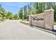 An elegant brick entrance with 'Wyndgate' sign, set against a backdrop of lush greenery and a clear blue sky at 1723 Cortleigh Dr, Trinity, FL 34655