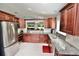 Spacious kitchen featuring wood cabinets, granite countertops, stainless steel appliances, and tile flooring at 1723 Cortleigh Dr, Trinity, FL 34655