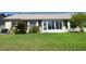 Manicured backyard shows lush lawn and mature plantings; the enclosed sunroom is attached to the house at 18418 Bent Pine Dr, Hudson, FL 34667