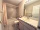 Neutral bathroom features a vanity with a sink and tub-shower with tan tiling at 18418 Bent Pine Dr, Hudson, FL 34667