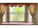 Close-up of a charming bay window with decorative curtains and window seat at 18418 Bent Pine Dr, Hudson, FL 34667