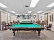 Bright billiard room featuring multiple pool tables with overhead lighting and comfortable seating around each table at 18418 Bent Pine Dr, Hudson, FL 34667