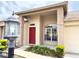 Close up of a home's front entrance, highlighting the bright red door and lush front yard landscaping at 18418 Bent Pine Dr, Hudson, FL 34667