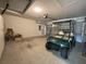 Spacious garage featuring a golf cart, overhead lighting, and a large door to the exterior at 18418 Bent Pine Dr, Hudson, FL 34667