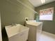 Laundry room features white appliances, a sink basin, shelf, and a bright window with floral curtains at 18418 Bent Pine Dr, Hudson, FL 34667