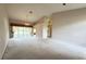 Expansive living room featuring neutral colored walls, a chandelier, and sliding glass door at 18418 Bent Pine Dr, Hudson, FL 34667