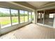 Bright sunroom with neutral rug, large windows, and glass door that offers expansive backyard views at 18418 Bent Pine Dr, Hudson, FL 34667