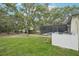 The grassy backyard featuring the pool in an enclosure and a wooden pergola at 18633 Oak Way Dr, Hudson, FL 34667