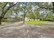 Large grassy backyard featuring a pool, surrounded by trees, with plenty of space for outdoor activities at 18633 Oak Way Dr, Hudson, FL 34667