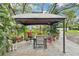 Outdoor patio featuring a covered gazebo and seating area with foliage and trees at 18633 Oak Way Dr, Hudson, FL 34667