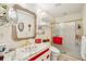 Bright bathroom featuring decorative vanity, an elegant gold-framed mirror, and a glass-enclosed shower at 18633 Oak Way Dr, Hudson, FL 34667