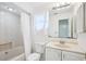 Bright bathroom featuring a shower-tub combo, white fixtures, and a large mirror at 18633 Oak Way Dr, Hudson, FL 34667
