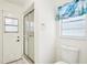 Clean bathroom with a glass-door shower and decorative ocean-themed window treatment at 18633 Oak Way Dr, Hudson, FL 34667