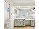 Bathroom featuring vanity with makeup desk, large mirrors, and enclosed toilet area at 18633 Oak Way Dr, Hudson, FL 34667