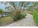 Paver driveway leads to the garage and a large backyard with a pool, showcasing the exterior landscape at 18633 Oak Way Dr, Hudson, FL 34667