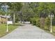 Long driveway, lamp posts and lush greenery with single-story home in the background at 18633 Oak Way Dr, Hudson, FL 34667