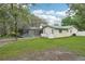 A home's backyard featuring a swimming pool with a screen enclosure, surrounded by a grassy yard at 18633 Oak Way Dr, Hudson, FL 34667