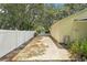 Driveway and fence with foliage and a view of the side of the house at 18633 Oak Way Dr, Hudson, FL 34667