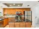 Spacious kitchen with wooden cabinetry, stainless steel appliances, and a central island with black marble countertop at 18633 Oak Way Dr, Hudson, FL 34667