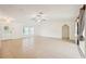 Light-filled living room with neutral tile flooring, windows, and an arched doorway at 18633 Oak Way Dr, Hudson, FL 34667