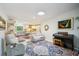 Bright, open-concept living space featuring a cozy seating area, piano, and view into the kitchen at 18633 Oak Way Dr, Hudson, FL 34667