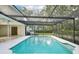 An in-ground screened pool surrounded by a white tile area, all enclosed with screen at 18633 Oak Way Dr, Hudson, FL 34667