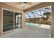A covered patio with ceiling fan leads to a screened-in pool and backyard area at 18710 Dobson Dr, Hudson, FL 34667