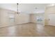 Spacious living room featuring tile flooring, large windows, and a modern chandelier at 18710 Dobson Dr, Hudson, FL 34667