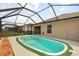 Screened-in backyard pool with small patio and green turf surround at 18710 Dobson Dr, Hudson, FL 34667