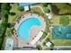 Aerial view of a large community pool, playground, and other amenities with lush landscaping and clear blue water at 19082 Umberland Pl, Land O Lakes, FL 34638