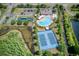 Aerial view showcases community amenities including pool, tennis courts, playground, basketball court, and lush green spaces at 19082 Umberland Pl, Land O Lakes, FL 34638