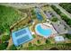 An aerial view of community amenities, including a large pool, tennis courts, playground, and surrounding natural beauty at 19082 Umberland Pl, Land O Lakes, FL 34638
