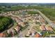 Aerial view of a well-planned community featuring beautiful homes, a pond, and a surrounding lush green landscape at 19082 Umberland Pl, Land O Lakes, FL 34638