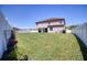 Large backyard featuring a lush lawn, privacy fence, and a covered patio at 19082 Umberland Pl, Land O Lakes, FL 34638