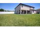 Expansive backyard featuring lush green grass, a privacy fence, and a covered patio at 19082 Umberland Pl, Land O Lakes, FL 34638
