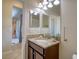 Well-lit bathroom featuring a vanity with granite countertops and view to a connecting room at 19082 Umberland Pl, Land O Lakes, FL 34638